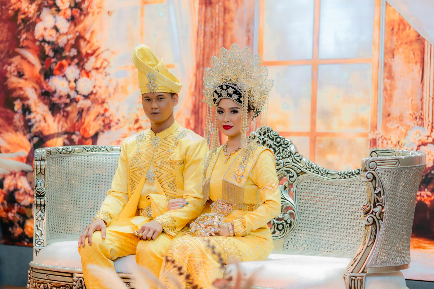 Wedding couple seated on stage in traditional attire