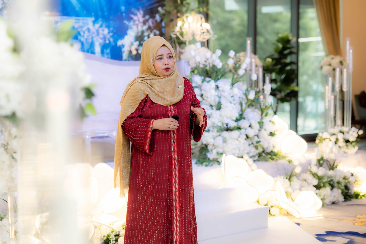 Speaker hosting a programme in front of the decorated stage